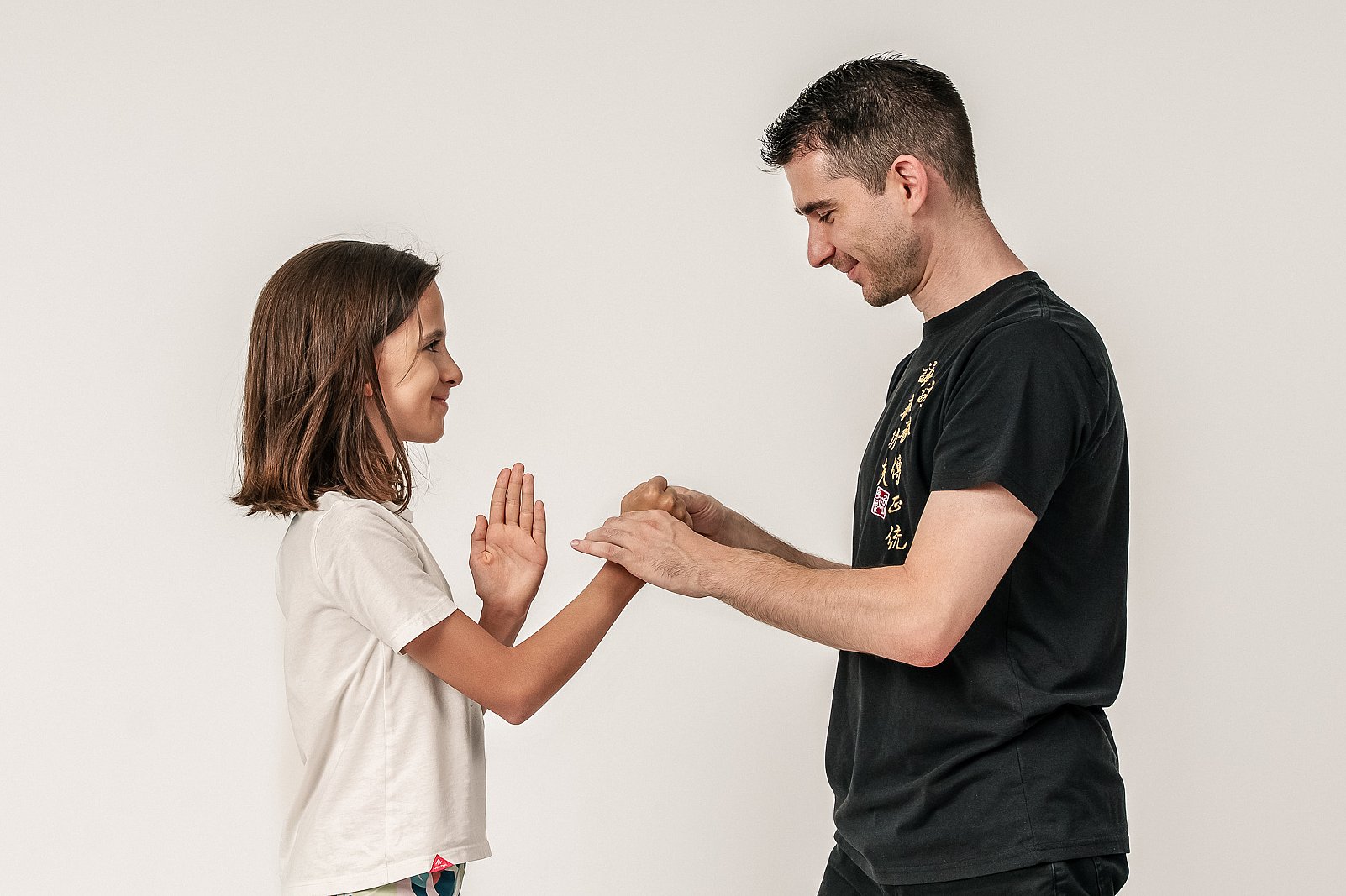 Vincenzo Rocco und ein Kind stehen sich gegenüber und führen gemeinsam eine Ving-Tsun-Partnerübung aus