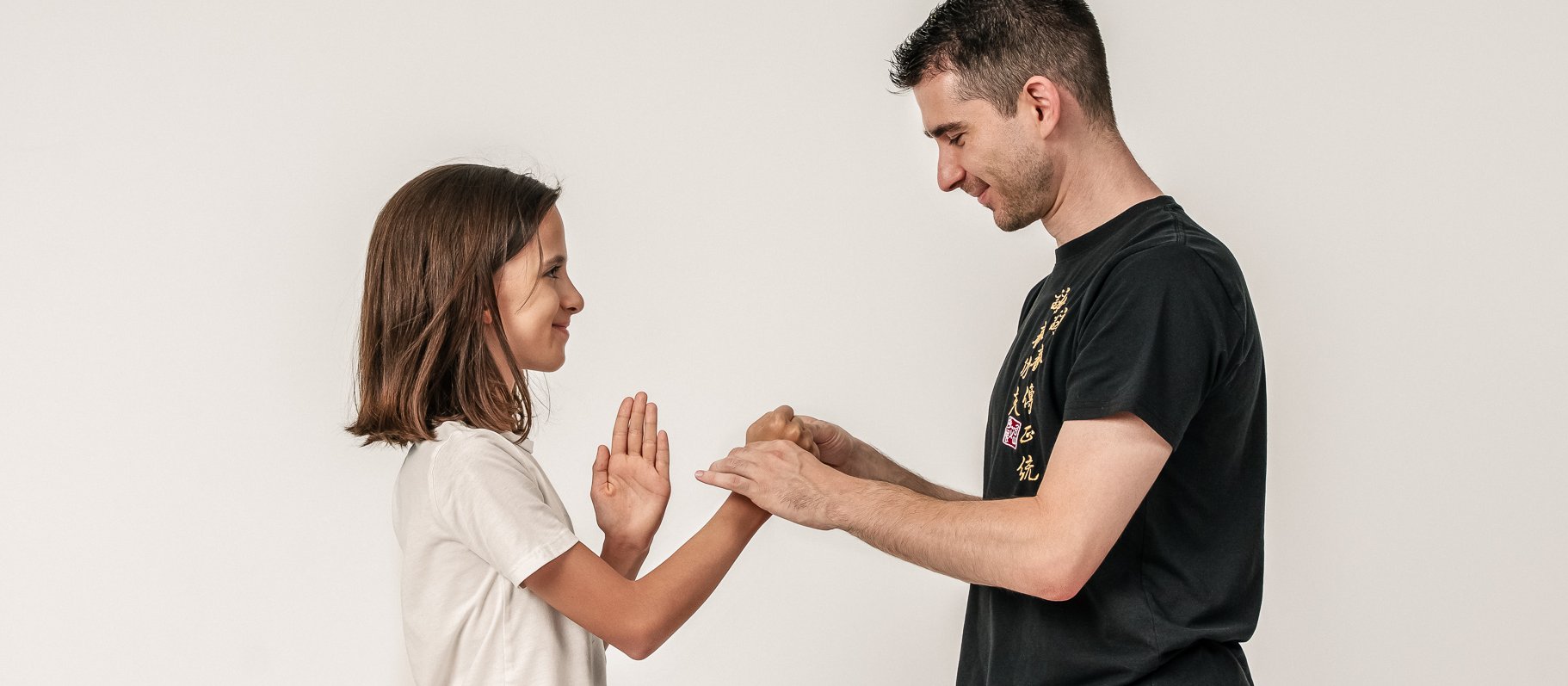 Vincenzo Rocco und ein Kind stehen sich gegenüber und führen gemeinsam eine Ving-Tsun-Partnerübung aus