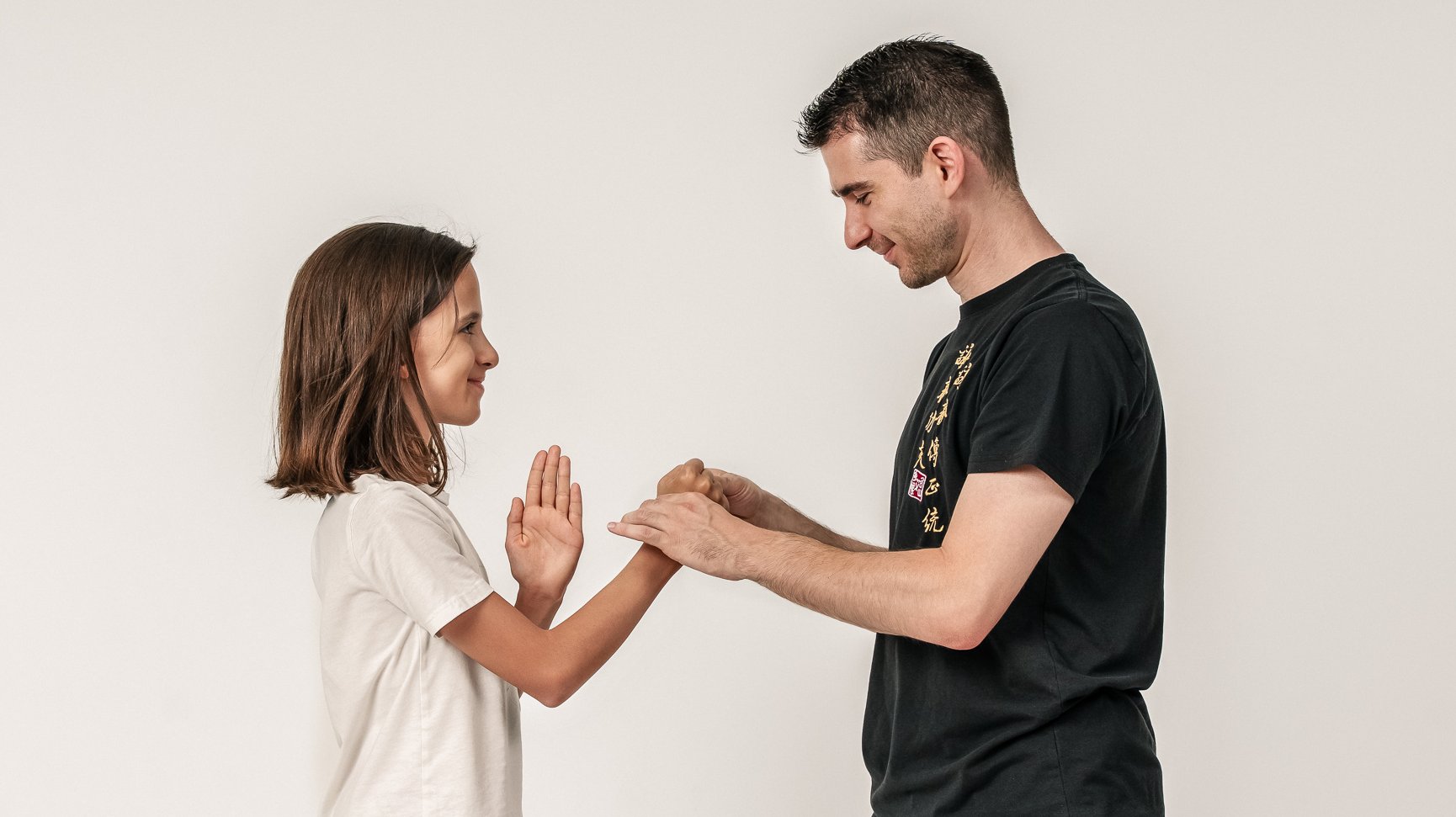 Vincenzo Rocco und ein Kind stehen sich gegenüber und führen gemeinsam eine Ving-Tsun-Partnerübung aus