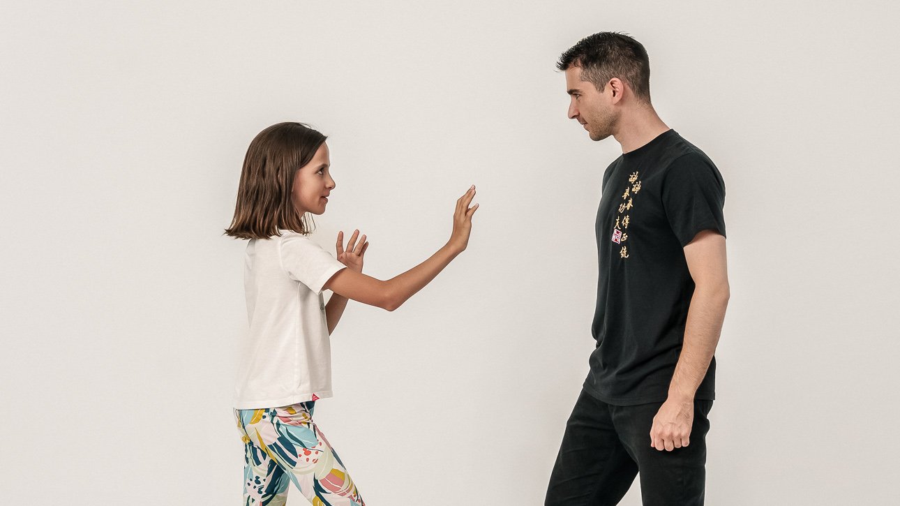 Vincenzo Rocco und ein Kind stehen sich gegenüber und führen gemeinsam eine Selbstbehauptungs-Übung aus