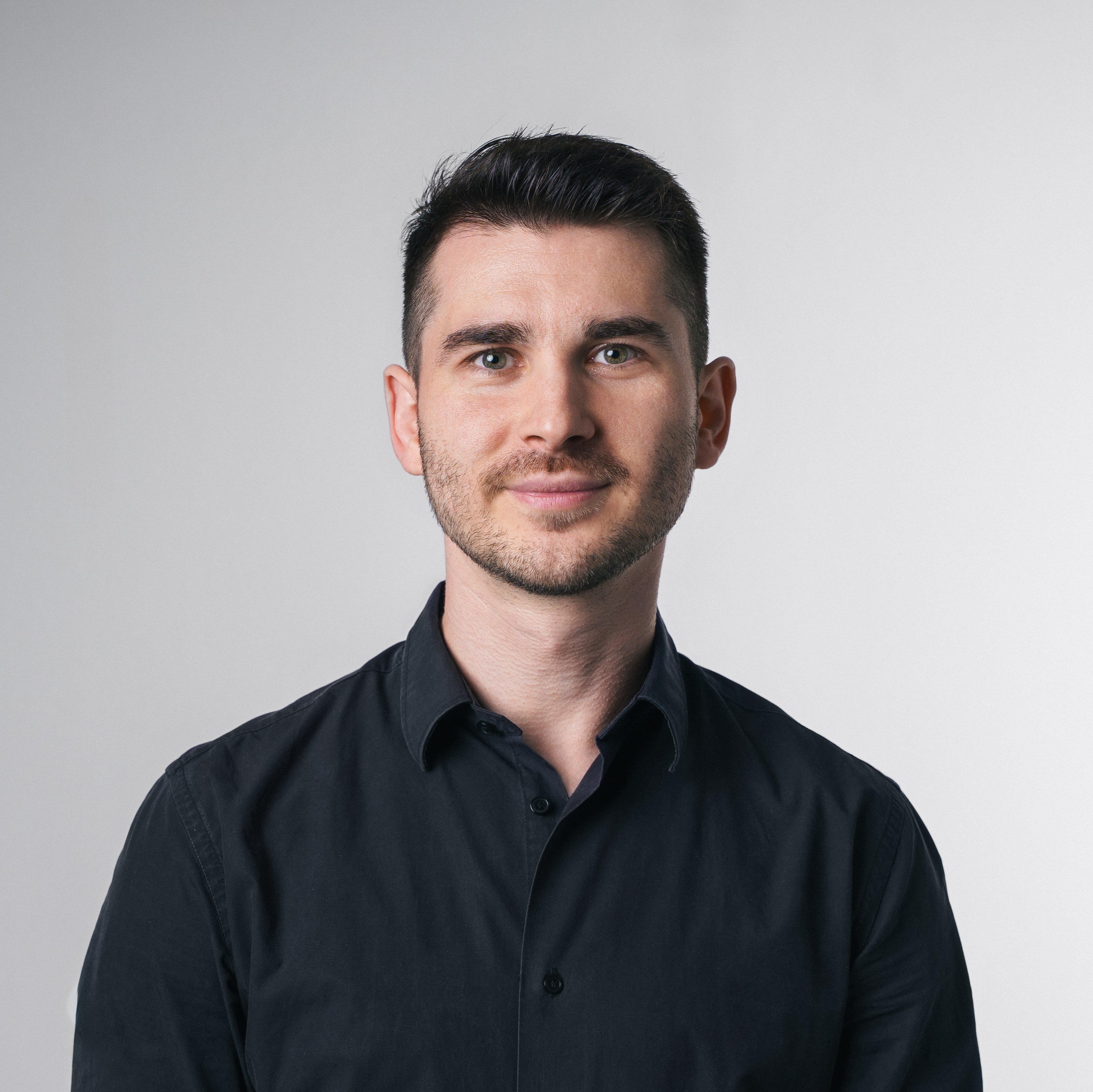 Vincenzo Rocco steht vor einem hellen Hintergrund und blickt direkt in die Kamera