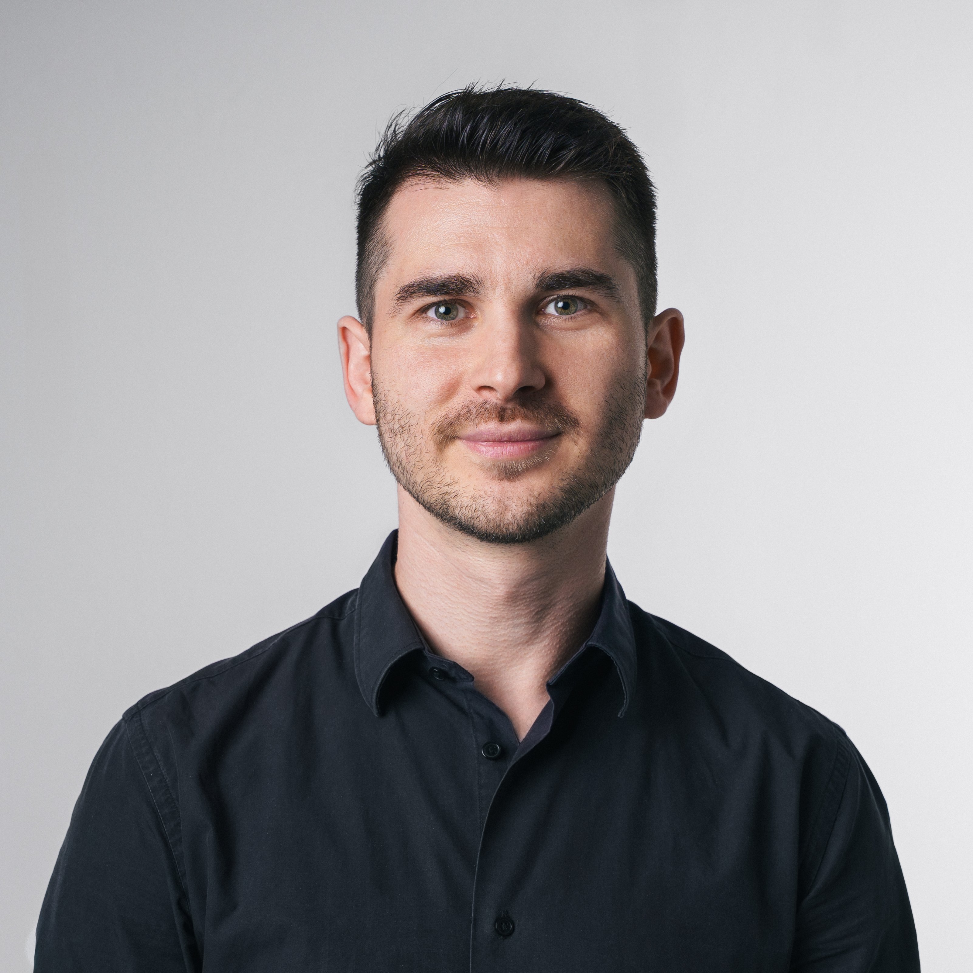 Vincenzo Rocco steht vor einem hellen Hintergrund und blickt direkt in die Kamera