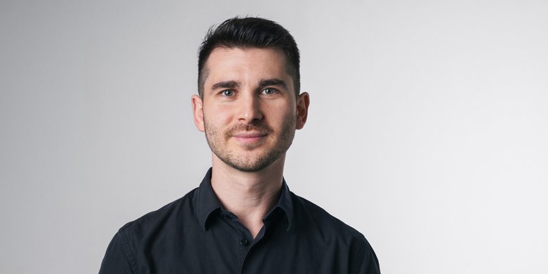 Vincenzo Rocco steht vor einem hellen Hintergrund und blickt direkt in die Kamera